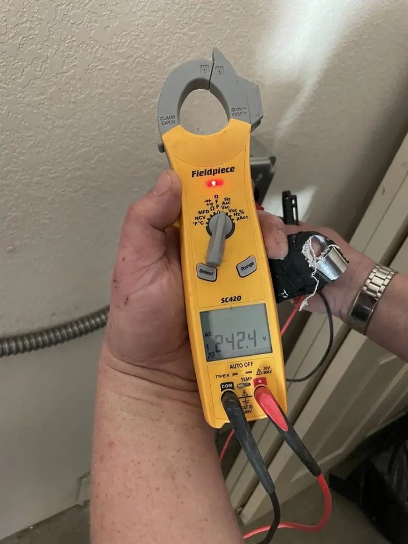 Voltage testing with clamp meter during Ceiling Fan Installation in Clover